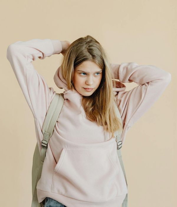 A focused teenage girl in a yoga pose on a mat, surrounded by soft aquamarine light.