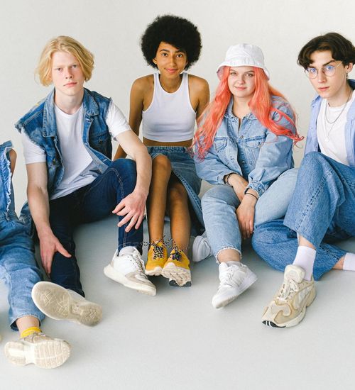 A group of teenagers happily practicing yoga together in a bright, modern studio.