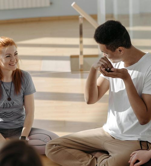 Group of diverse teenagers meditating peacefully in a yoga studio environment.
